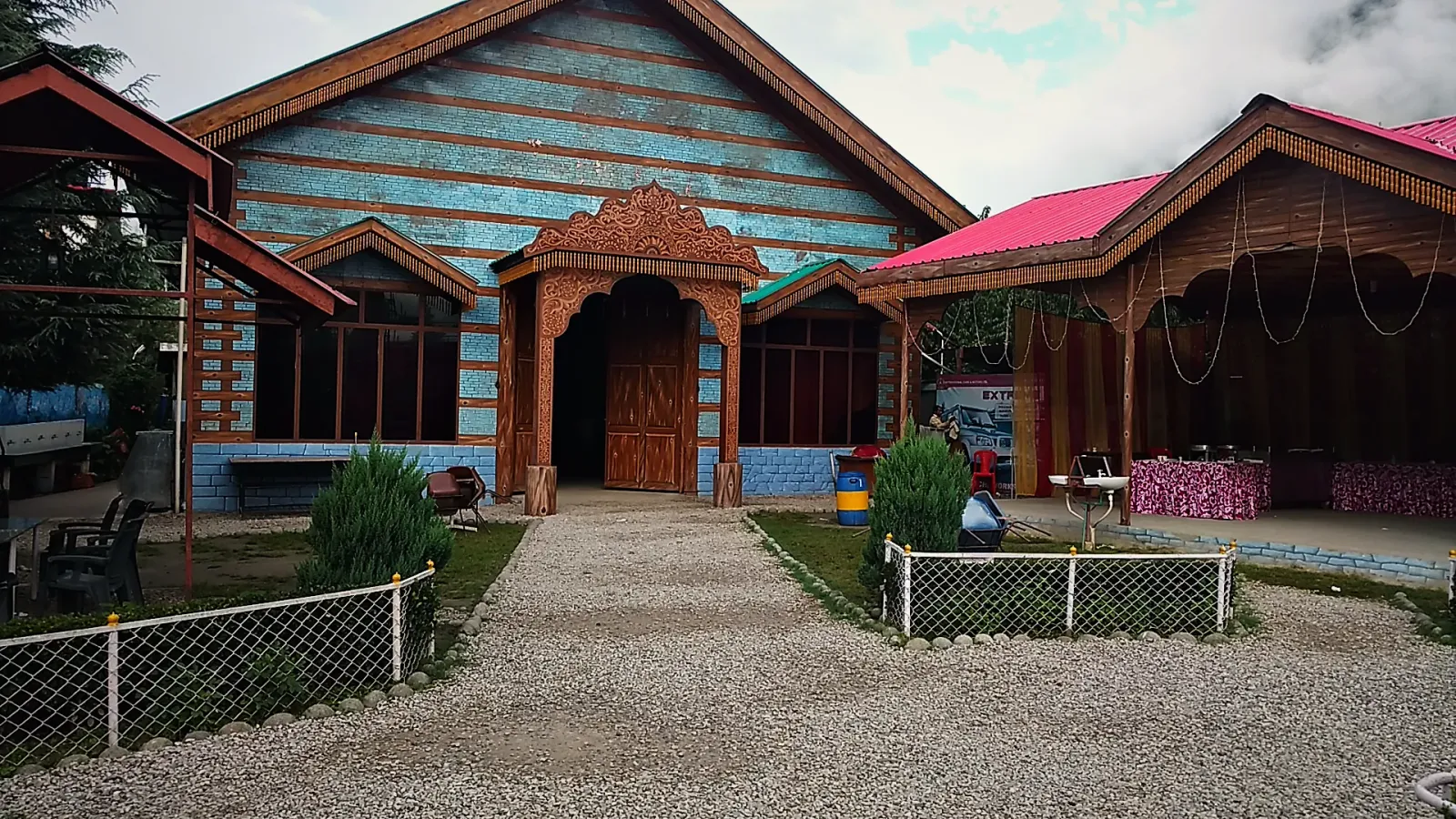 Carved wooden entrance of the banquet hall, flanked by red-roofed pavilions