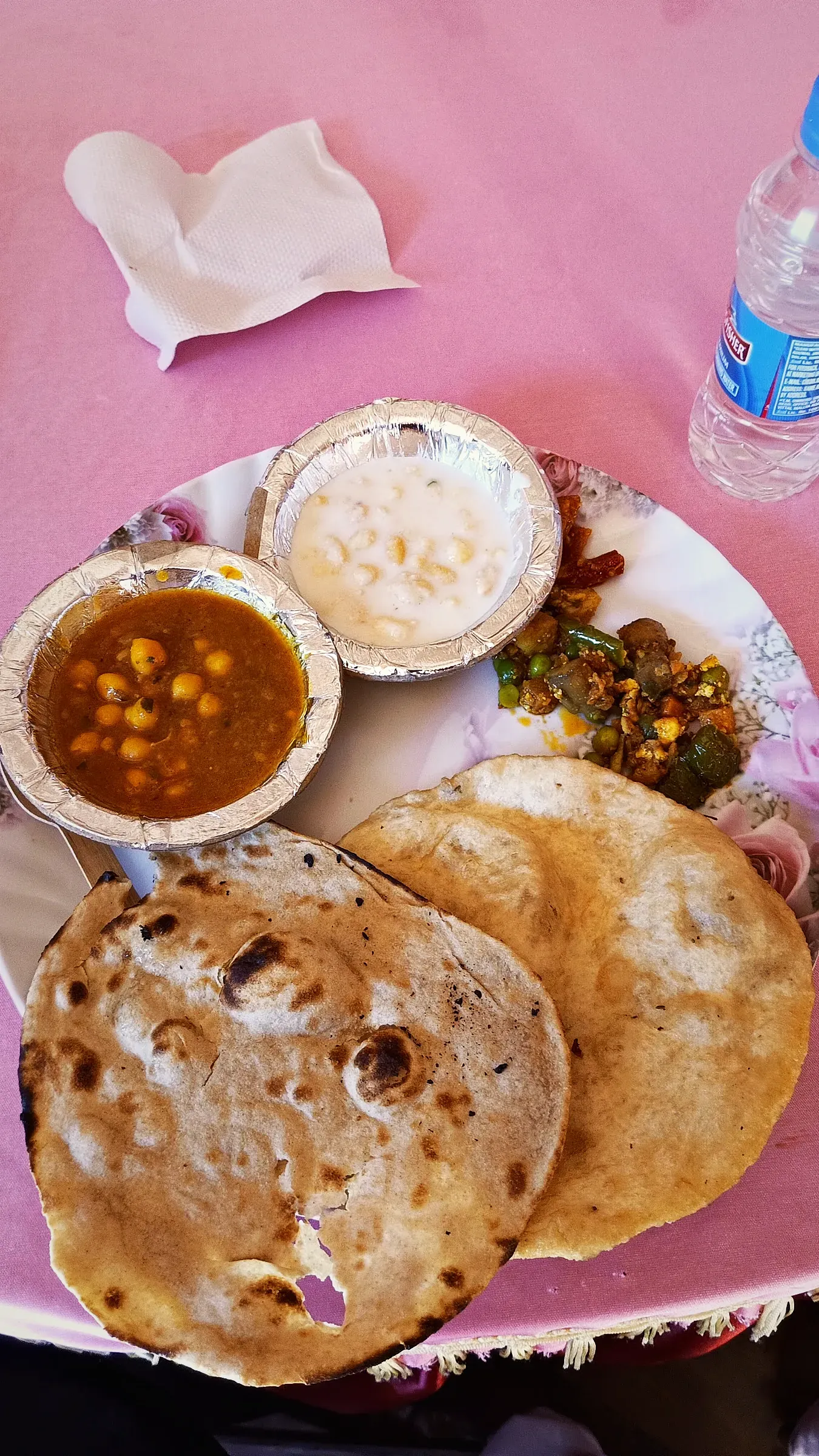 A thali with chole, raita and rotis