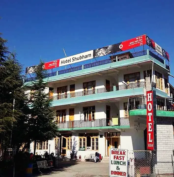 The Hotel Shubham building on the highway under a clear blue sky