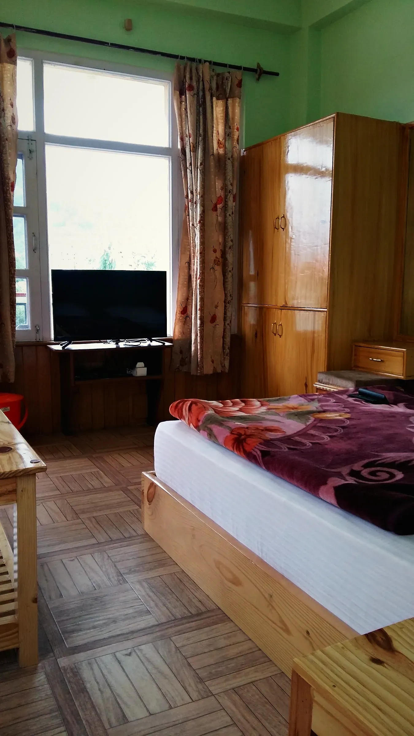 A wood-panelled guest room with a double bed